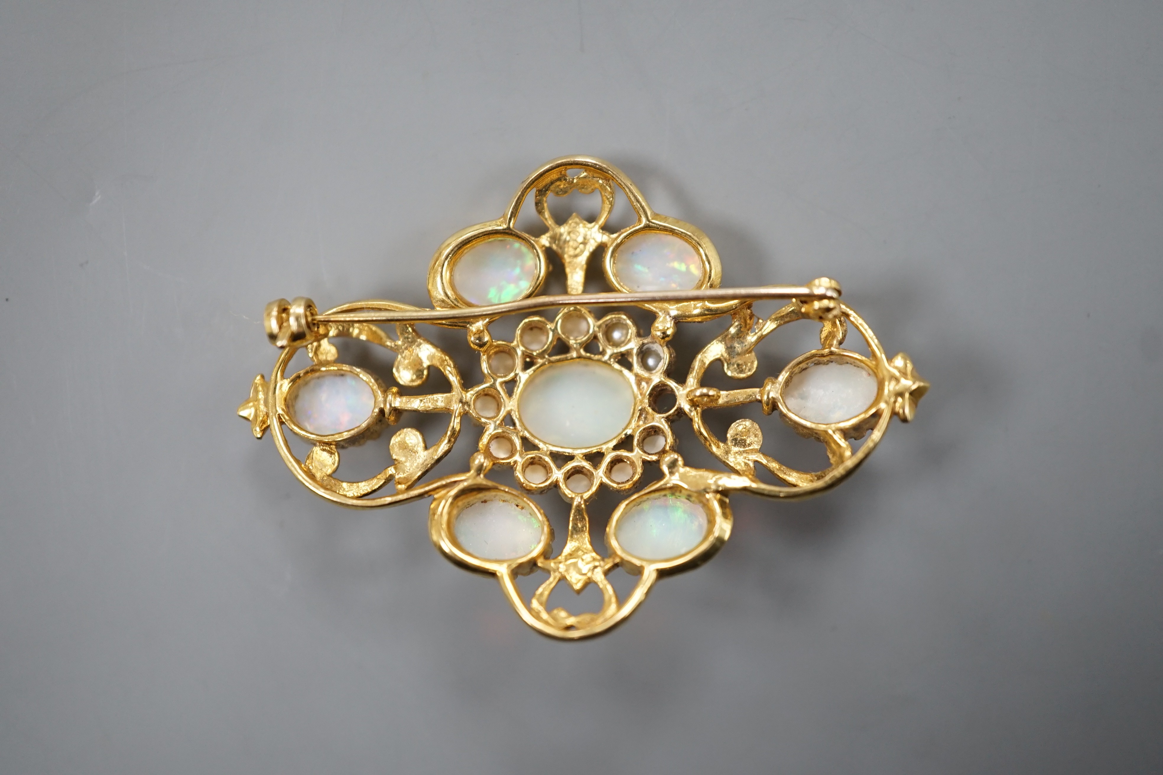 An early 1970's 9ct gold, graduated oval white opal and split pearl set brooch, of quatrefoil shape (pearl missing), 48mm, gross weight 9.3 grams.